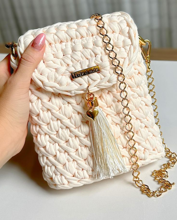Bolsa creme com tassel e corrente dourada